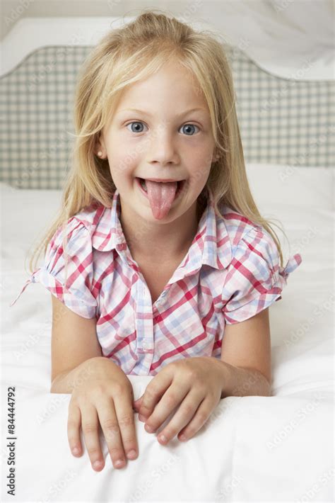 Young Girl Lying On Bed Pulling Funny Face Foto De Stock Adobe Stock
