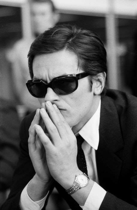 Black And White Photograph Of A Man In Sunglasses Holding His Hand To His Face While Sitting At