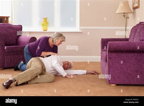Woman Bending Over Elderly Man Who Has Fallen Stock Photo Alamy