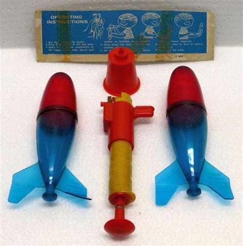 Three Toy Rockets Sitting Next To Each Other On A White Surface With