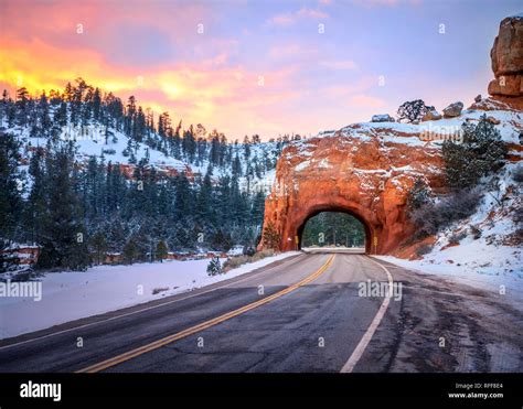 Road With Tunnel Through Red Rock Arch In Snow At Sunset Highway 12