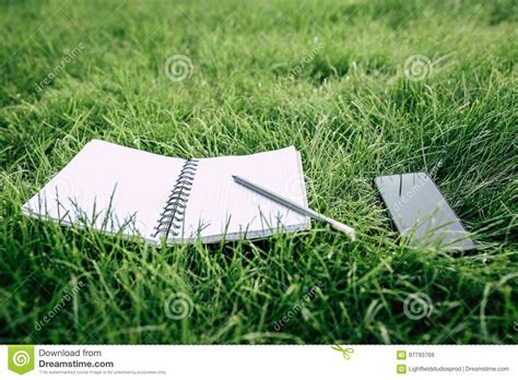 Smartphone With Blank Screen Empty Notebook And Pencil On Green Grass