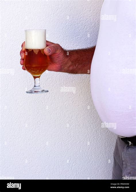 Big Beer Belly Man Holding A Glass Full Of Cold Beer Bubbles And Beer