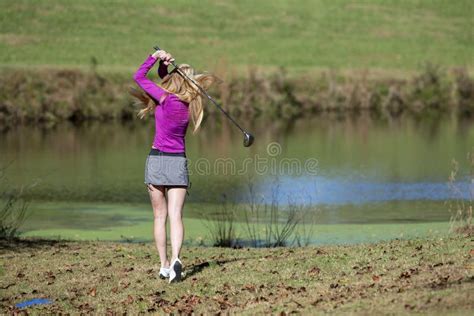 lovely blonde female golfter enjoying a round of golf on a public golf course stock image