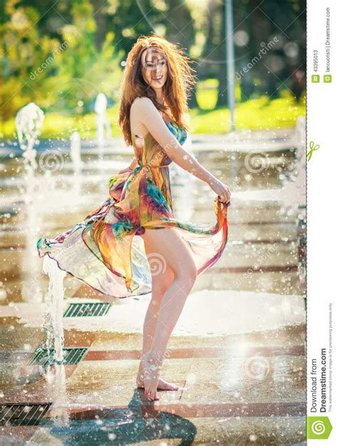 Aantrekkelijk Meisje In Het Multicolored Korte Kleding Spelen Met Water In Een De Zomer Heetste