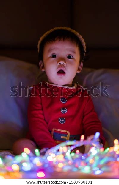 Baby Christmas Lights While Wearing Santas Stock Photo 1589930191