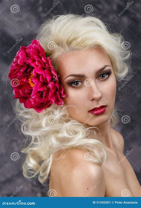 Beauty Portrait Of A Blonde With A Big Red Flower In Her Hair Stock