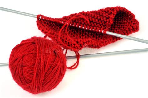 Ball Of Red Wool With A Knitting And Knitting Needles On A White