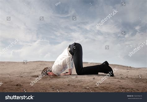 Young Businessman Burying His Head In The Sand Stock Photo 102476615