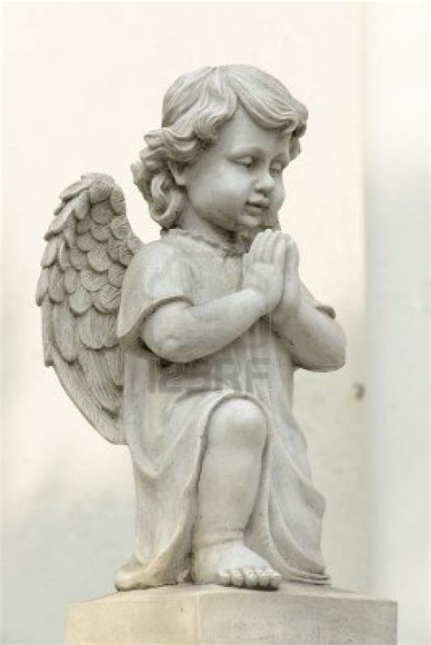 Cute Winged Angel Statue In Praying Pose With Side View Stock Photo