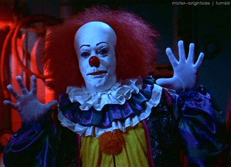 A Creepy Clown With Red Hair And White Makeup Holding His Hands Up In