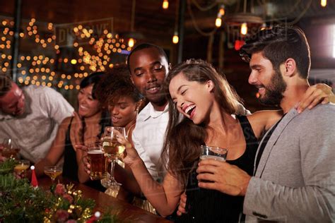 Friends having fun at a Christmas party in a bar - Stock Photo - Dissolve