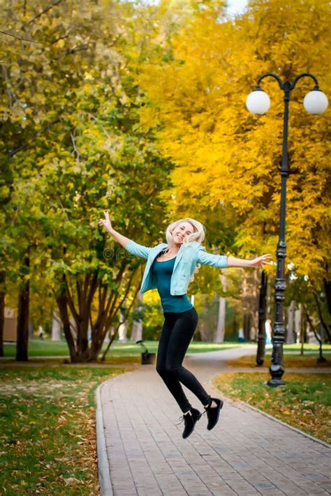 Happy Young Woman Jumping And Enjoying Life In Autumn Park Stock Image