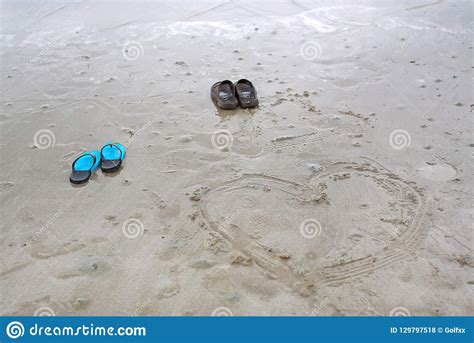 Couple Shoes On Beach With Painted Heart On Sand By The Sea In A Summer