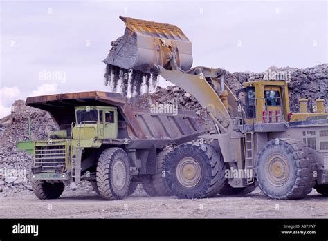 Front End Loader Loading A 100 Ton Dump Truck At A Limestone Quarry On