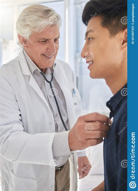 Listen Carefully A Mature Doctor Having A Checkup With A Patient At A Hospital Stock Image