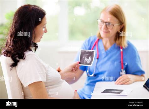 Doctor examining pregnant woman. Pregnancy check. Young Asian female at
