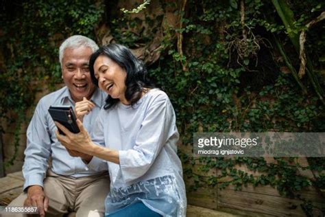 old asian couple on phone photos and premium high res pictures getty images