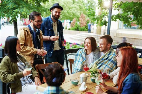 Cheerful Group Of Friends Meeting At Cafe Outdoors Stock Photo Dissolve