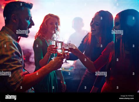 Cheering Friends With Champagne Enjoying Party In Nightclub Stock Photo