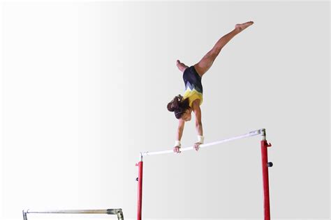A Person On A Balance Beam Doing A Handstand In The Middle Of An
