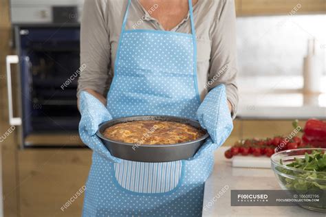 Cropped Image Of Mature Woman In Kitchen Carrying Homemade Cake