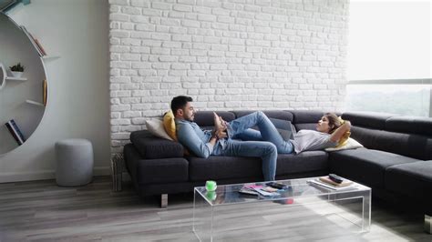 Man Massaging Girlfriend Feet On Sofa At Home Stock Footage SBV
