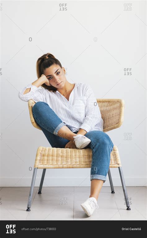 Young Woman With Hand On Head Sitting In Chair Stock Photo Offset