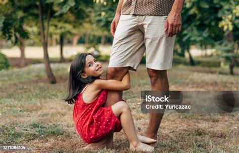 웃는 딸은 아버지와 함께 야외에서 아빠의 다리를 흔들고 있는 시간을 보내고 있습니다 공원에서 아빠와 놀고있는 누테 어린 소녀 아빠와 아이는 함께 즐거운 행복한 아버지의 날
