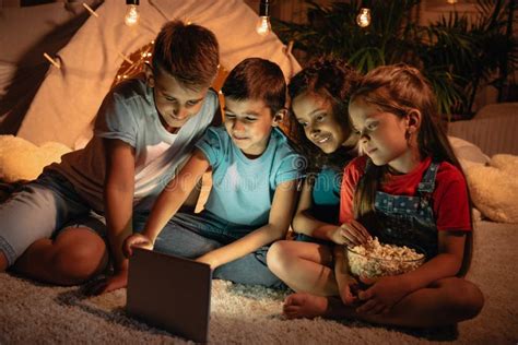 Kids Using Digital Tablet While Spending Time Together At Home Stock