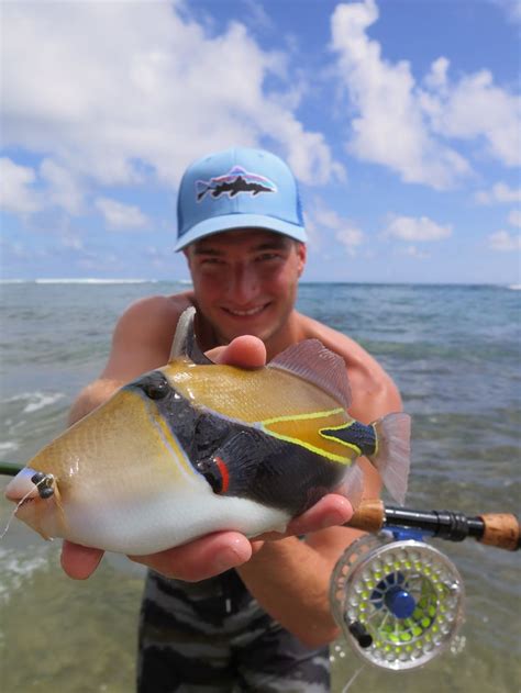 A Man Holding A Fish In His Hand