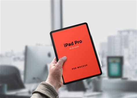Person sitting outside and using blank screen tablet. Hand holding iPad Pro Mockup | Mockup World