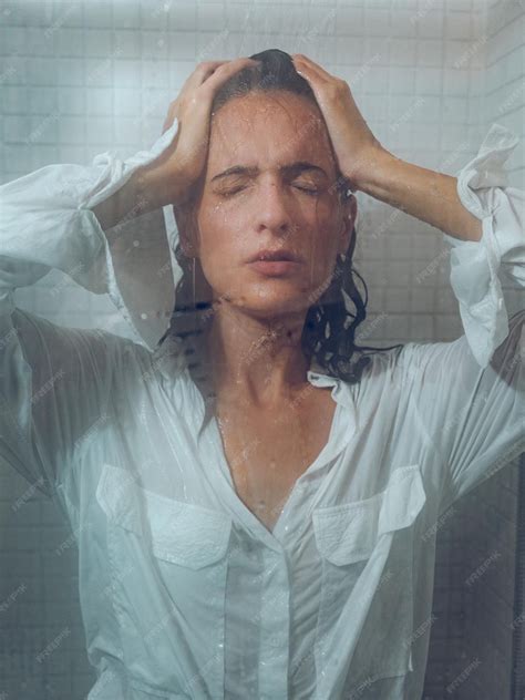 Premium Photo Sensual Female With Dark Wet Hair Wearing White Shirt Standing Under Splashing