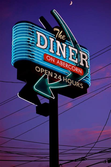 The Diner On Abercon Sign Is Lit Up At Night With An Arrow Pointing To