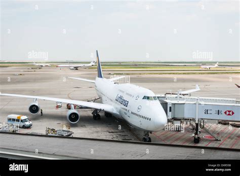 A Lufthansa German Airlines Jumbo Jet Is Parked At The Boarding Gate