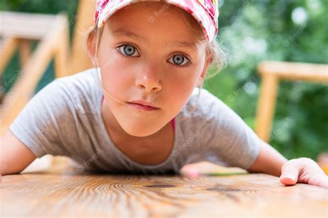 Premium Photo Portrait Of A Little Girl In A Cap Lying On Her Stomach