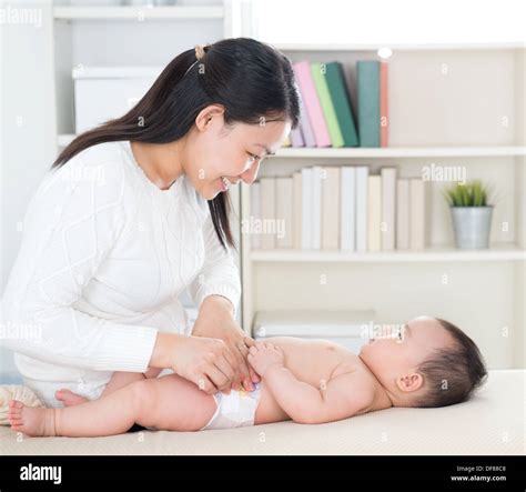 Asian Mother Changing Diaper To Baby Girl At Home Stock Photo Alamy