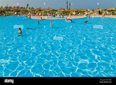 Horizontal Wide Angle Of A Busy Hotel Swimming Pool Surrounded By Lots
