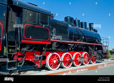 Old Russian Soviet Steam Locomotive On A Pedestal On A Background Of