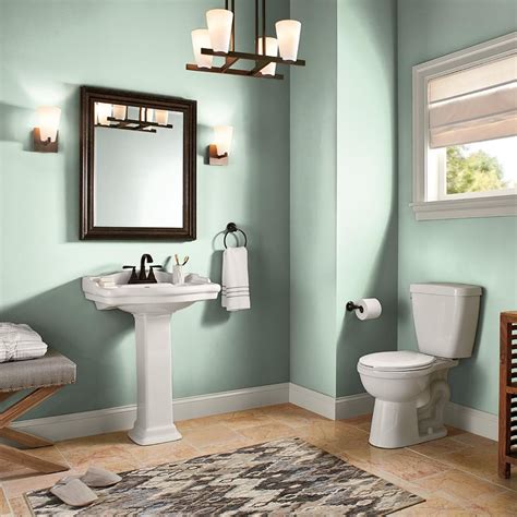 A Bathroom With Green Walls White Fixtures And A Rug On The Floor In