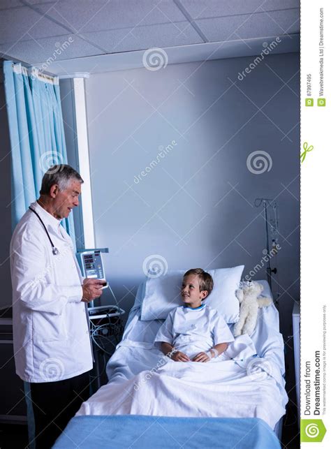 Male Doctor Interacting With Patient During Visit In Ward Stock Image