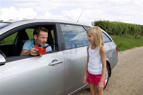 a male stranger in a car trying to lure a girl with candies stock image colourbox