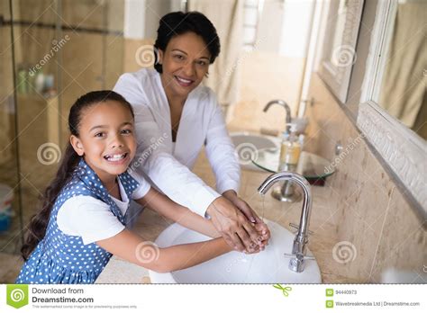 Portrait Of Grandmother And Granddaughter Washing Hands Stock Image