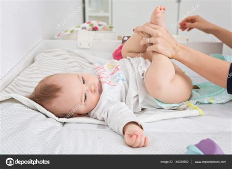 Mother Changing Diapers Of A Nine Months Old Baby Girl Daughter Stock