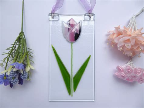 Three Different Flowers Are Displayed On A White Surface One Is Pink And The Other Is Green