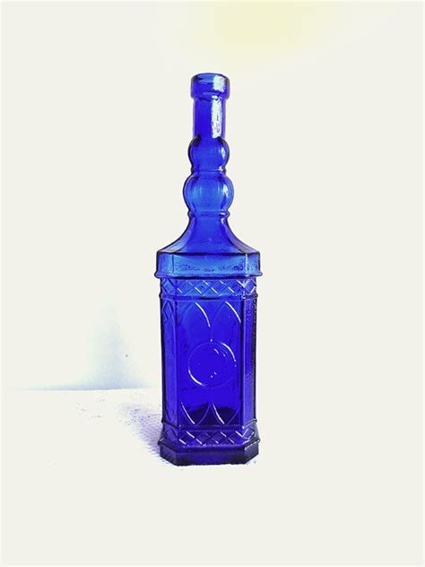 A Blue Glass Bottle Sitting On Top Of A Table