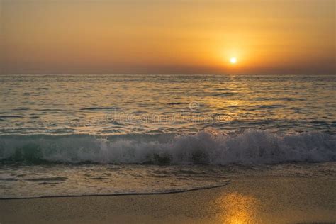Romantic Sunset On The Sandy Beach With Blue Sea WavesÂ Stock Photo