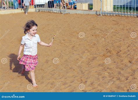 La Bambina Felice Funziona Con La Lecca Lecca Luminosa Sulla Sabbia