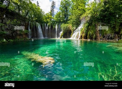 Pure Fresh Water Rushing Into An Azure Coloured Lake At The Plitvice