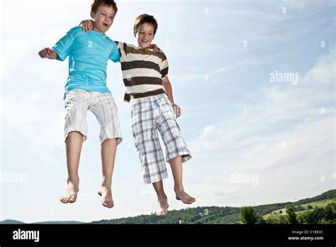 Two Boys Jumping On Trampoline Stock Photo Alamy